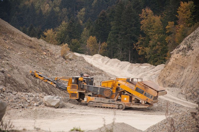 Mobile crusher processing material in a quarry